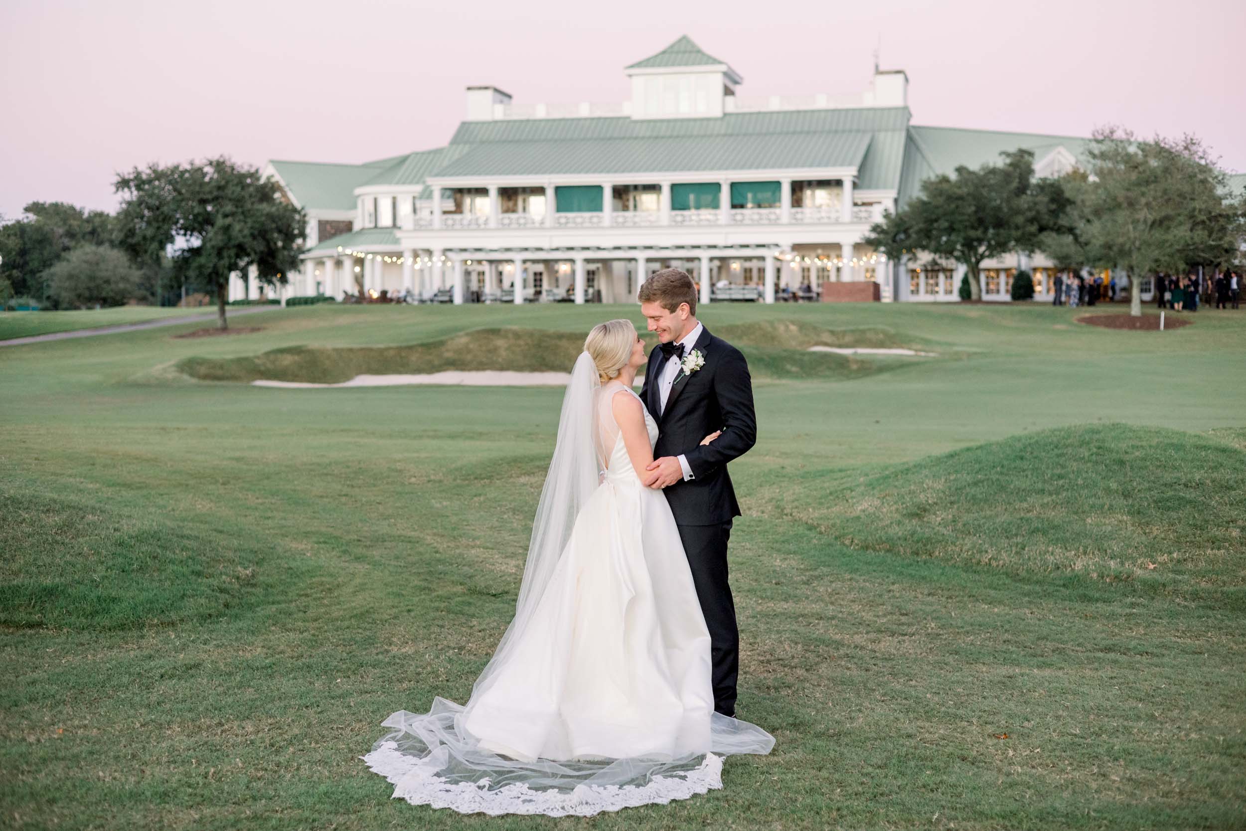 Bride and groom standing together on the lawn at Cape Fear Country Club, photographed by Cape Fear Country Club wedding photographers.