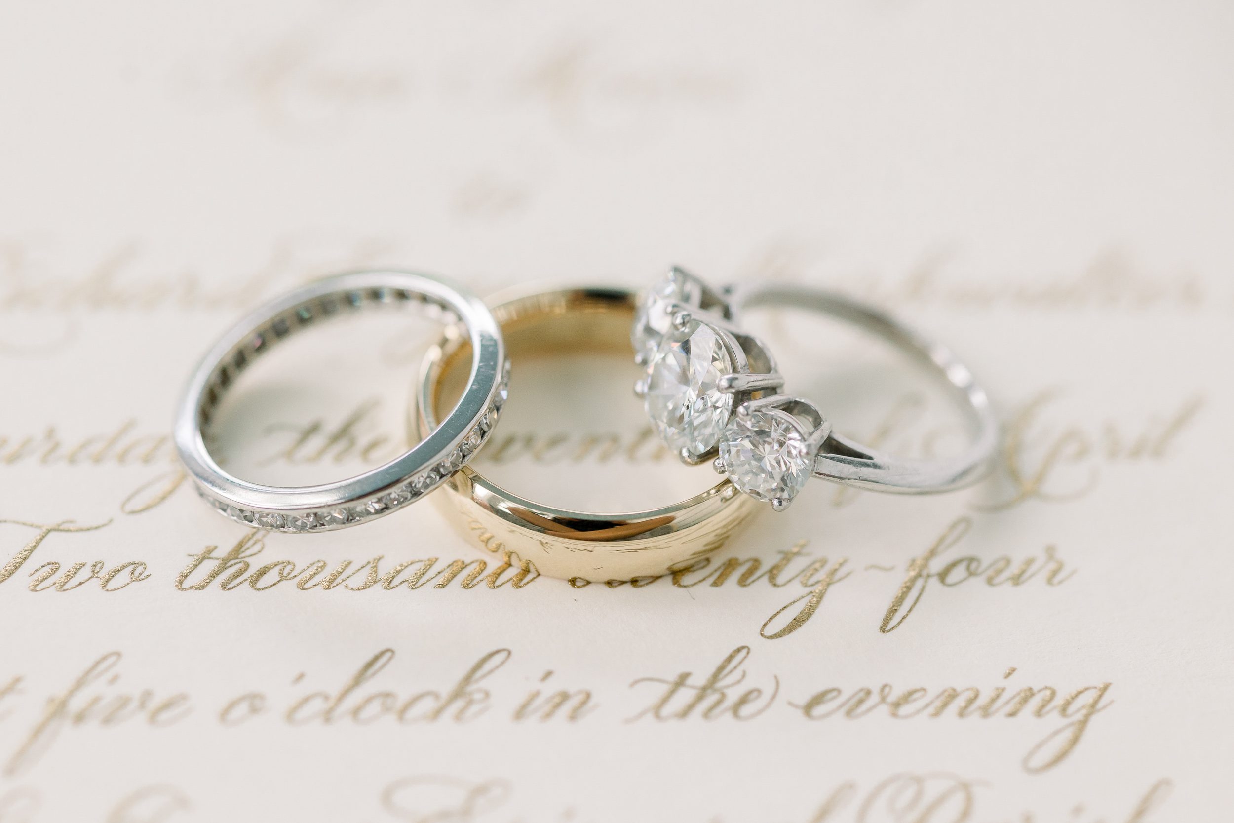 Wedding rings from a Sycamore Bend wedding in Wilmington NC displayed with elegant floral details and invitation suite
