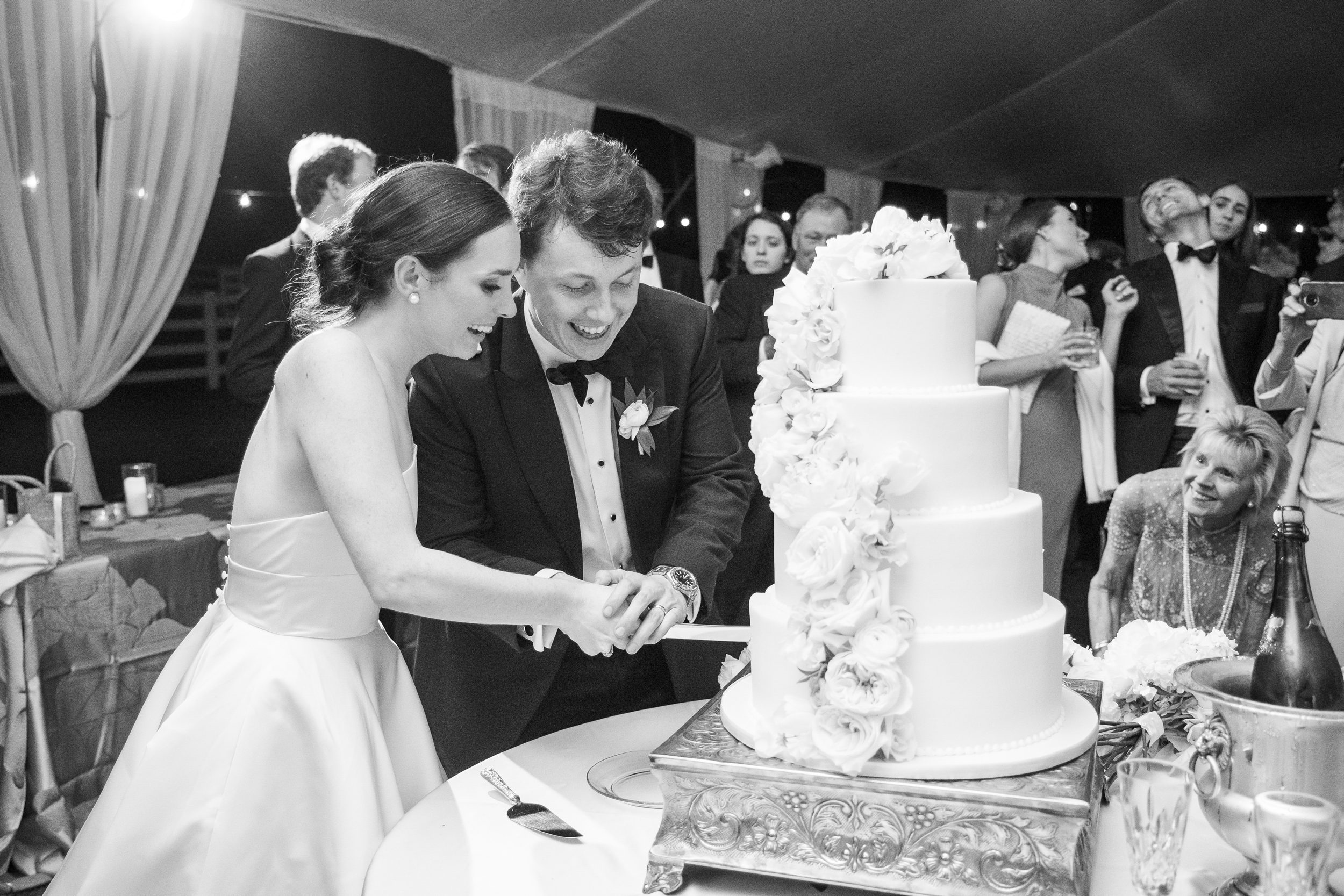Bride and groom cutting their wedding cake during the reception at Sycamore Bend Estate in Wilmington NC