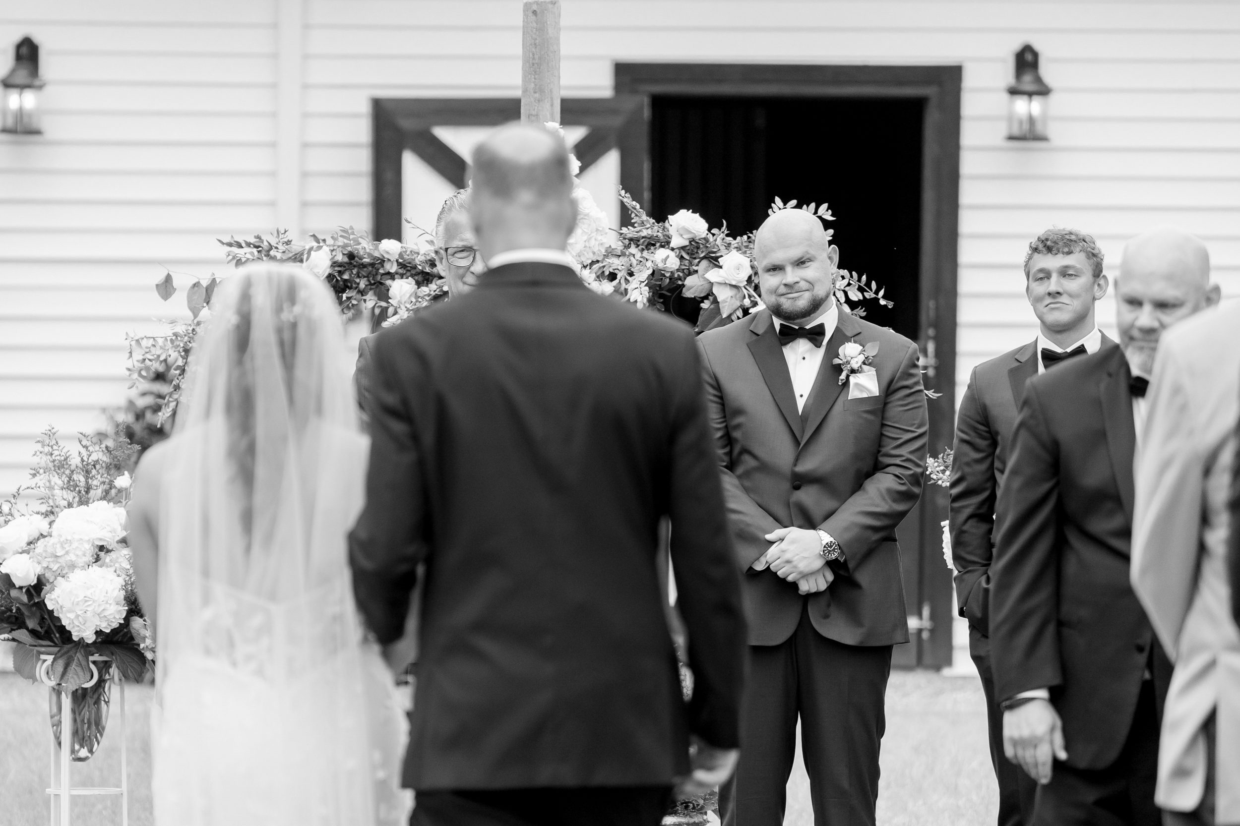 Black and white photo of groom seeing his bride for the first time during their Sycamore Bend wedding in Wilmington NC