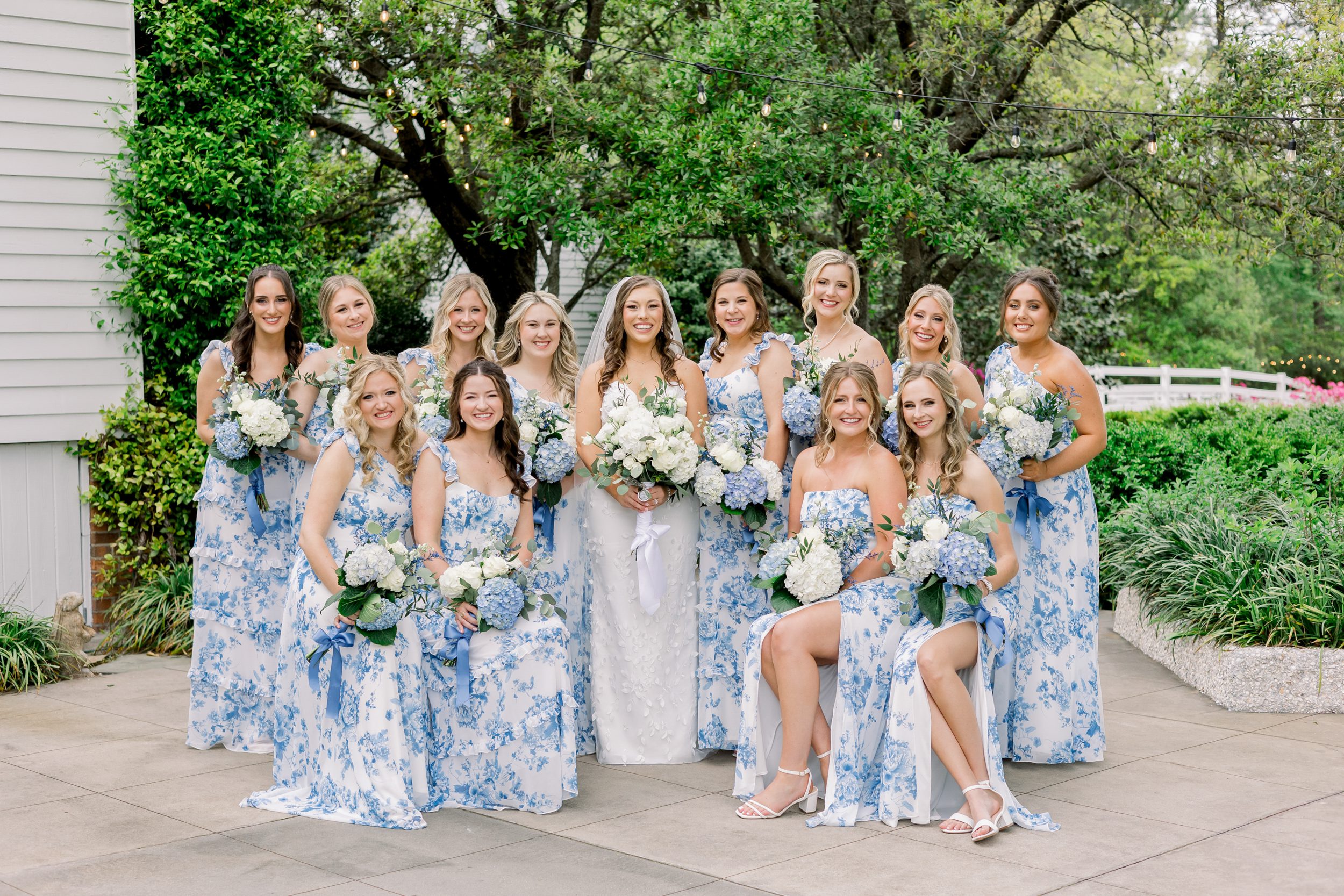 Bride with bridesmaids at Sycamore Bend wedding in Wilmington NC surrounded by beautiful gardens and blue florals