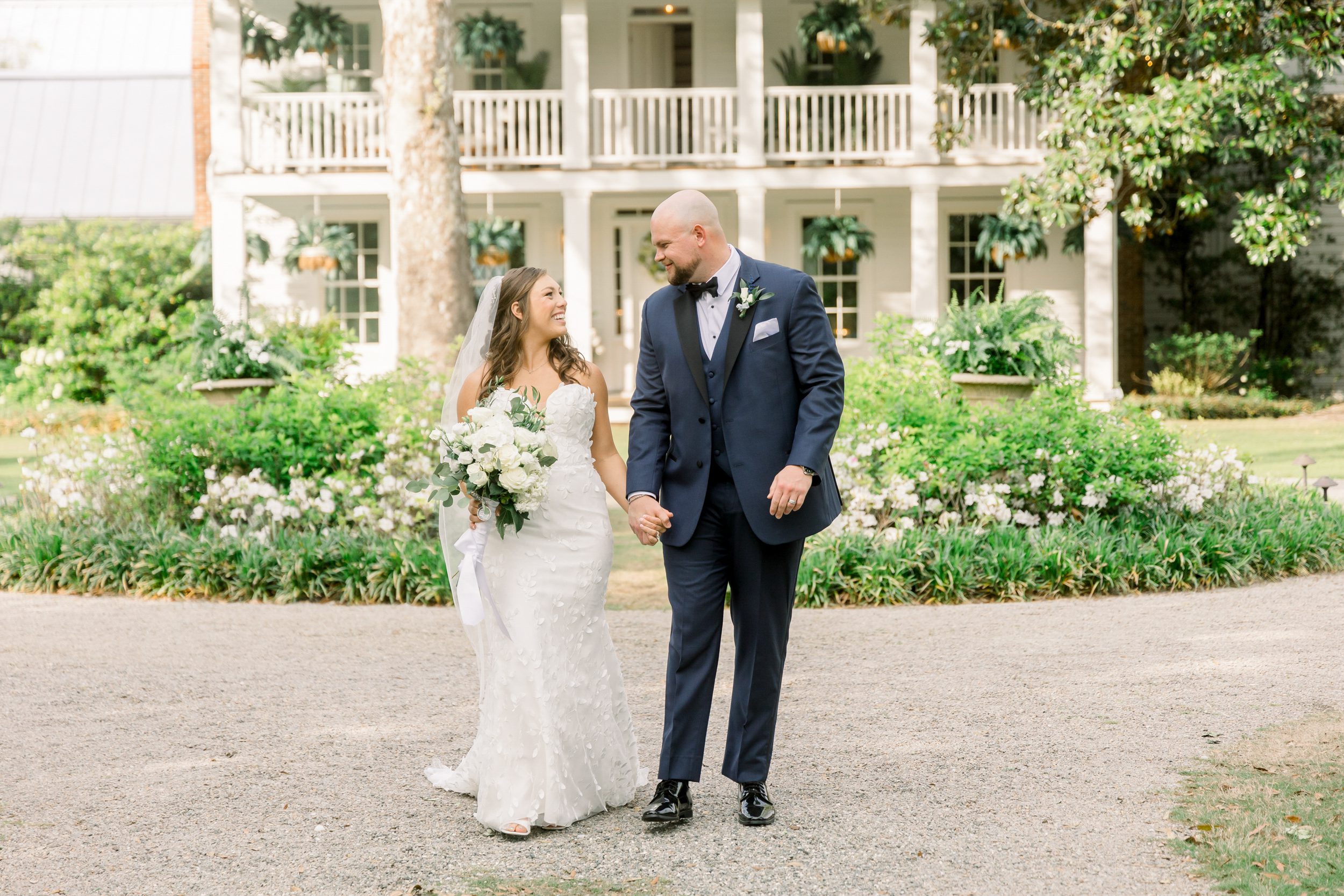 Bride and groom walking hand in hand at Sycamore Bend Estate in Wilmington NC during their wedding day