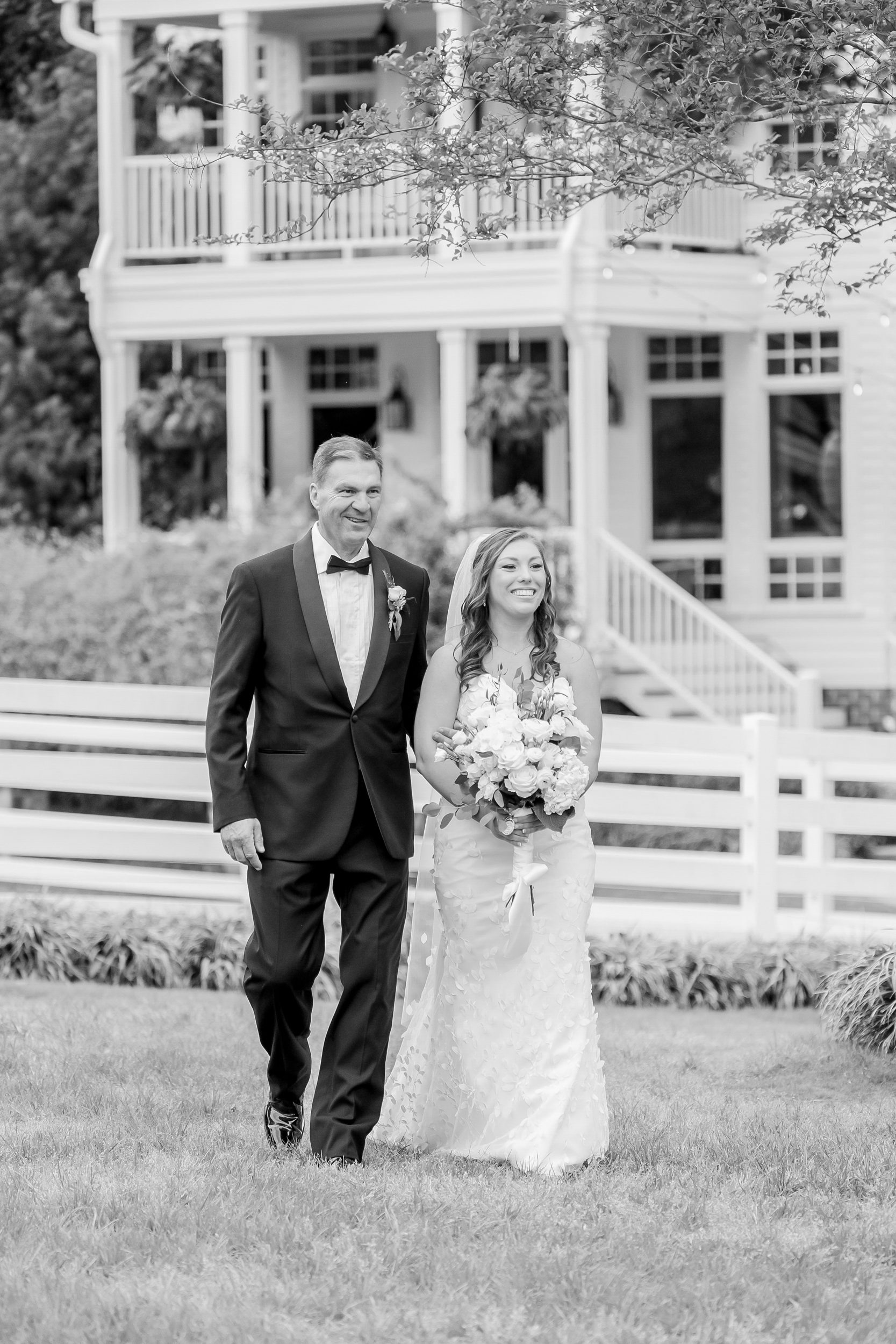 Bride and her dad walking toward the groom during an outdoor ceremony at Sycamore Bend Estate in Wilmington NC