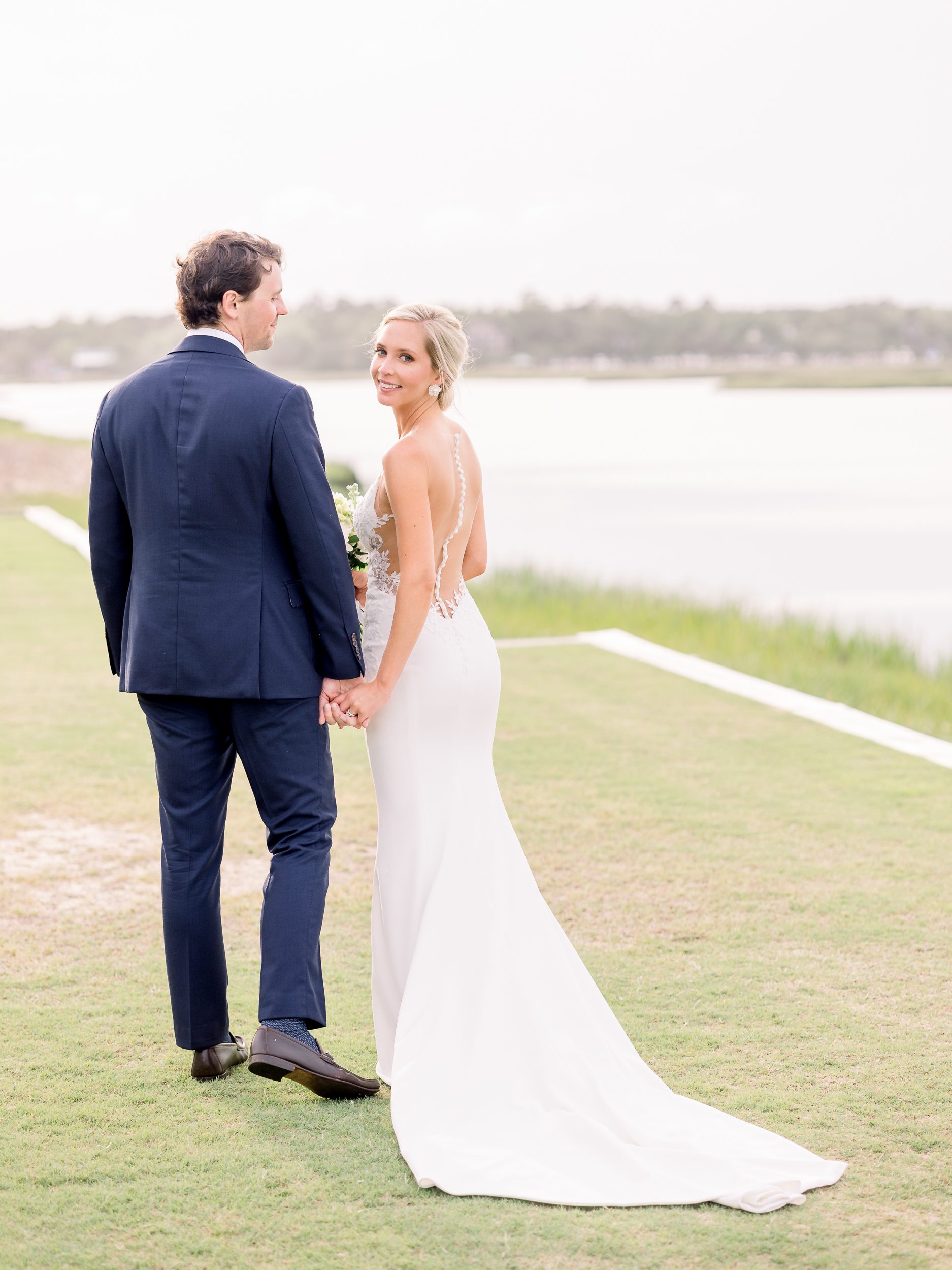 Bride and groom standing together at Figure Eight Island Country Club, captured by Wilmington NC wedding photographers.