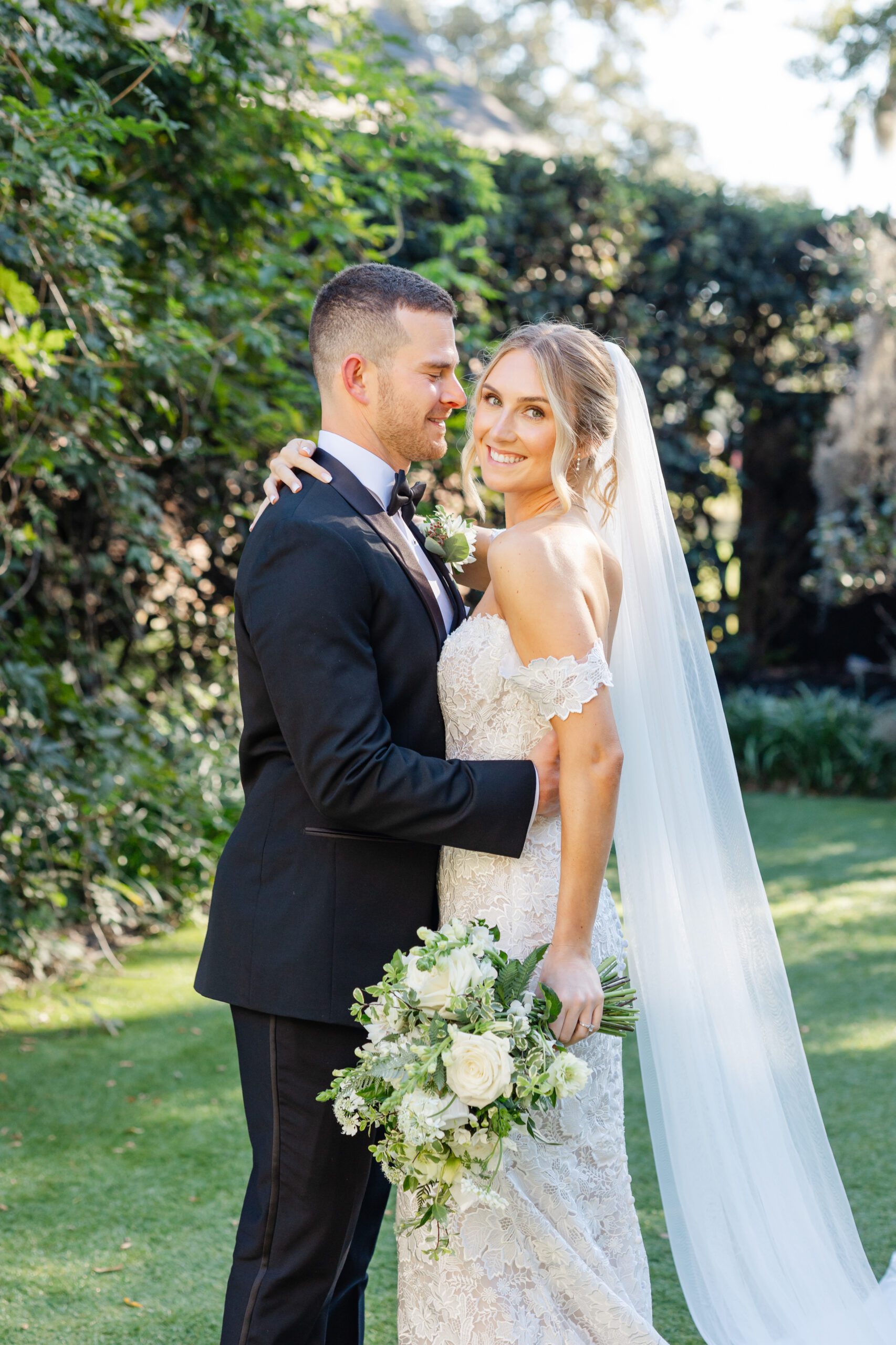 Bride and groom embracing softly in the courtyard at Wrightsville Manor, photographed by Wrightsville Manor wedding photographers.