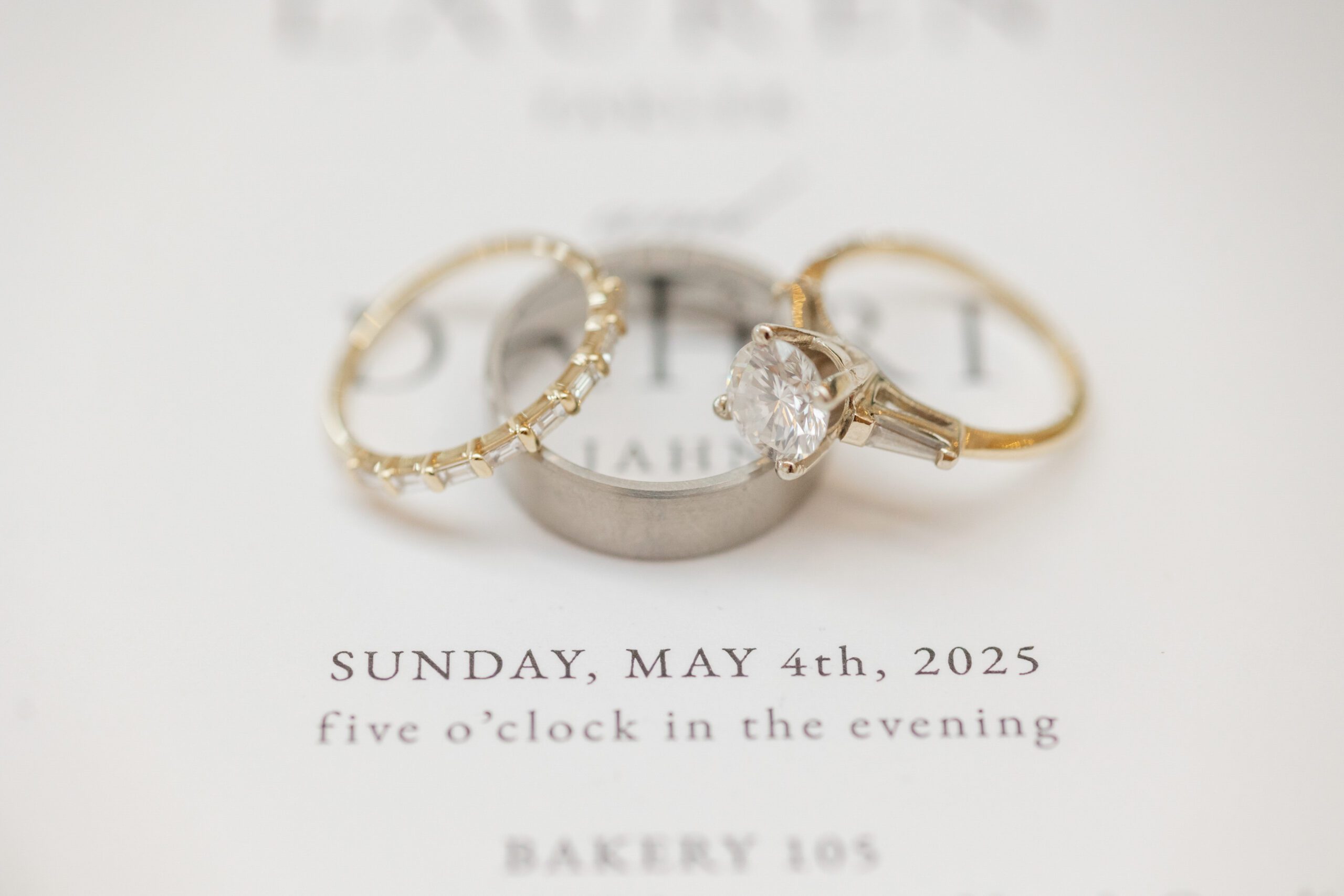 Wedding rings displayed on invitation at Bakery 105.
