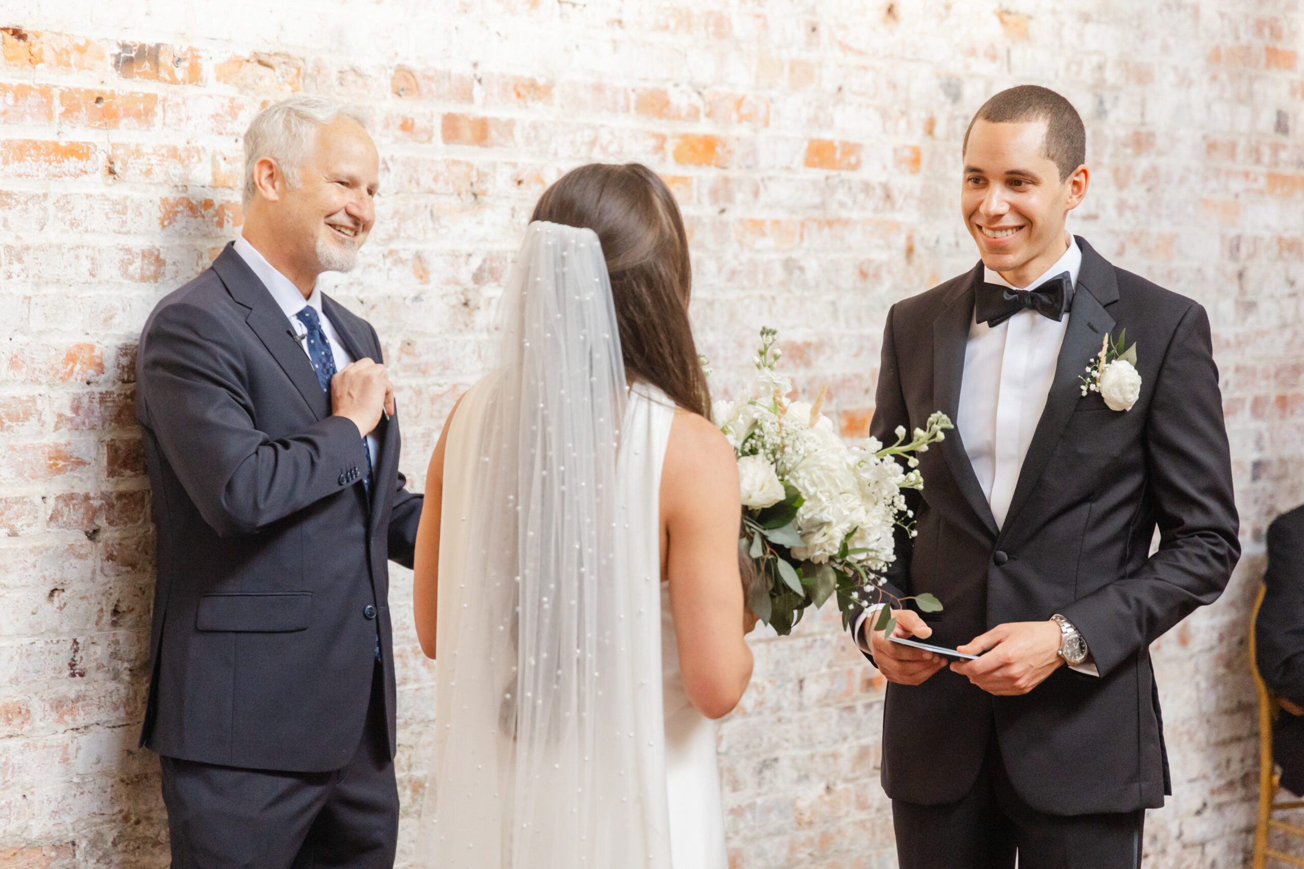 Groom reacting during the vow exchange at Bakery 105, photographed by Bakery 105 wedding photographers.