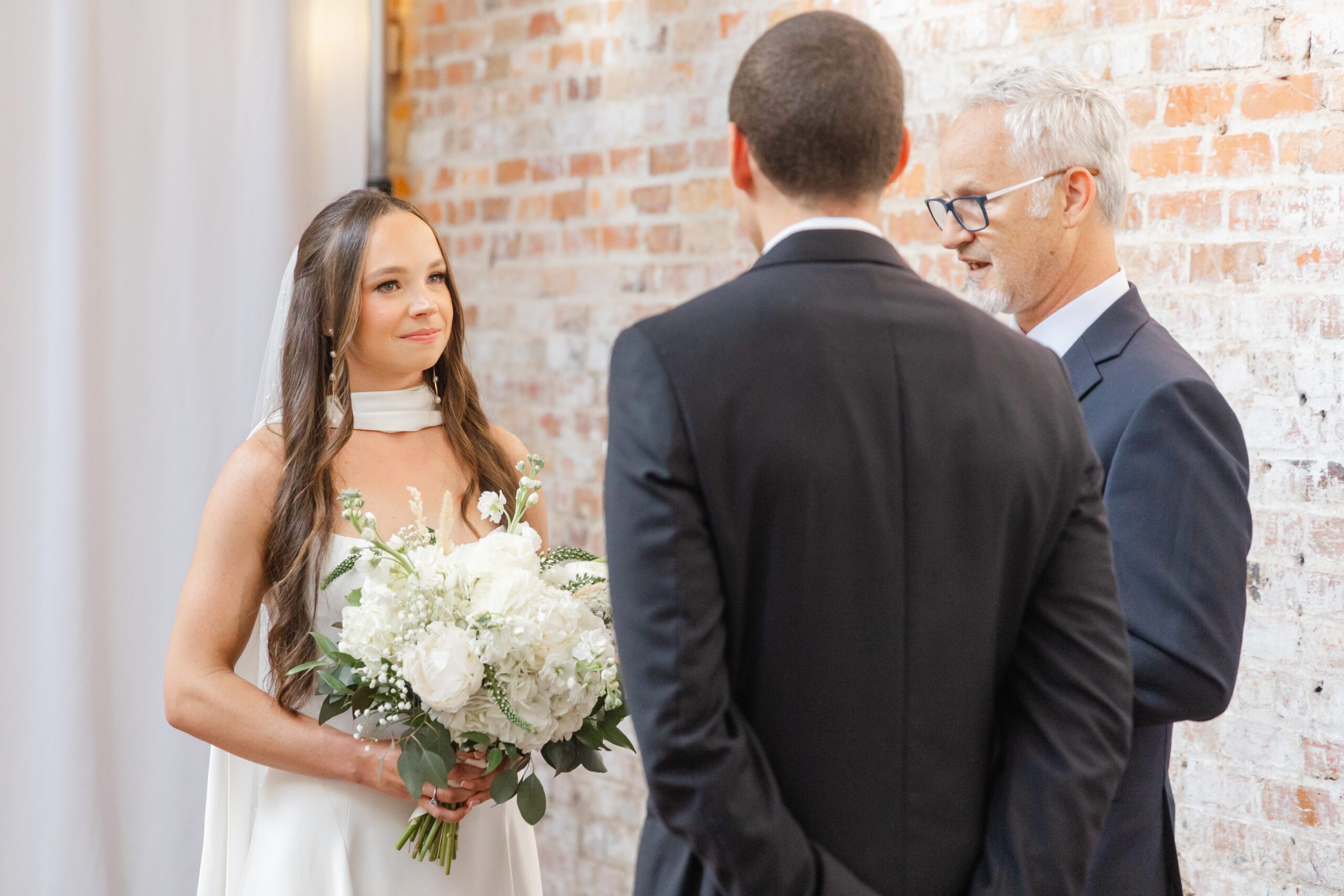 Bride and groom exchanging vows during their ceremony at Bakery 105 in Wilmington NC.