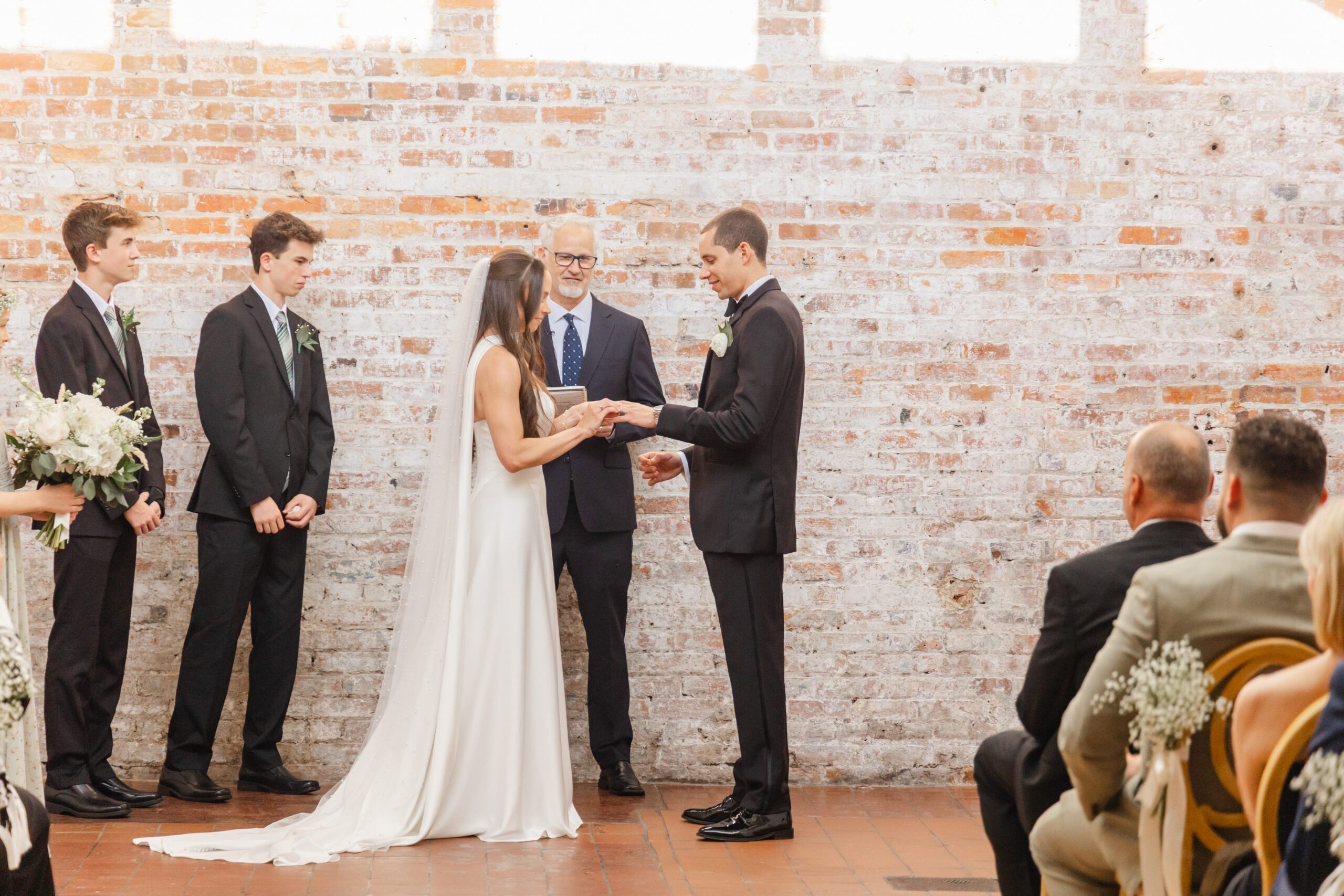 Wedding ceremony at Bakery 105 with guests seated indoors, photographed by Bakery 105 wedding photographers in Wilmington NC.