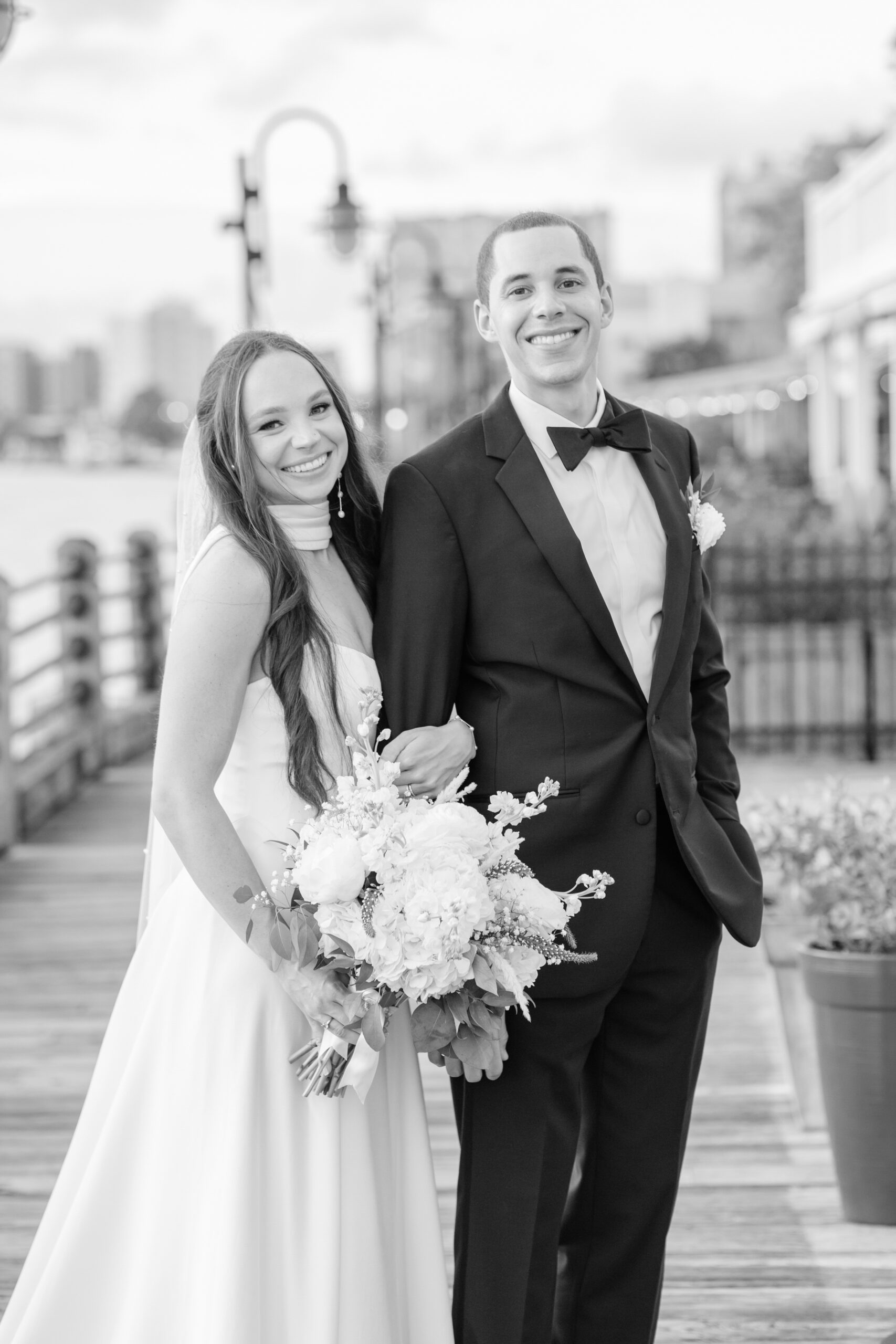 Couple standing together on the Wilmington Riverwalk overlooking the water.
