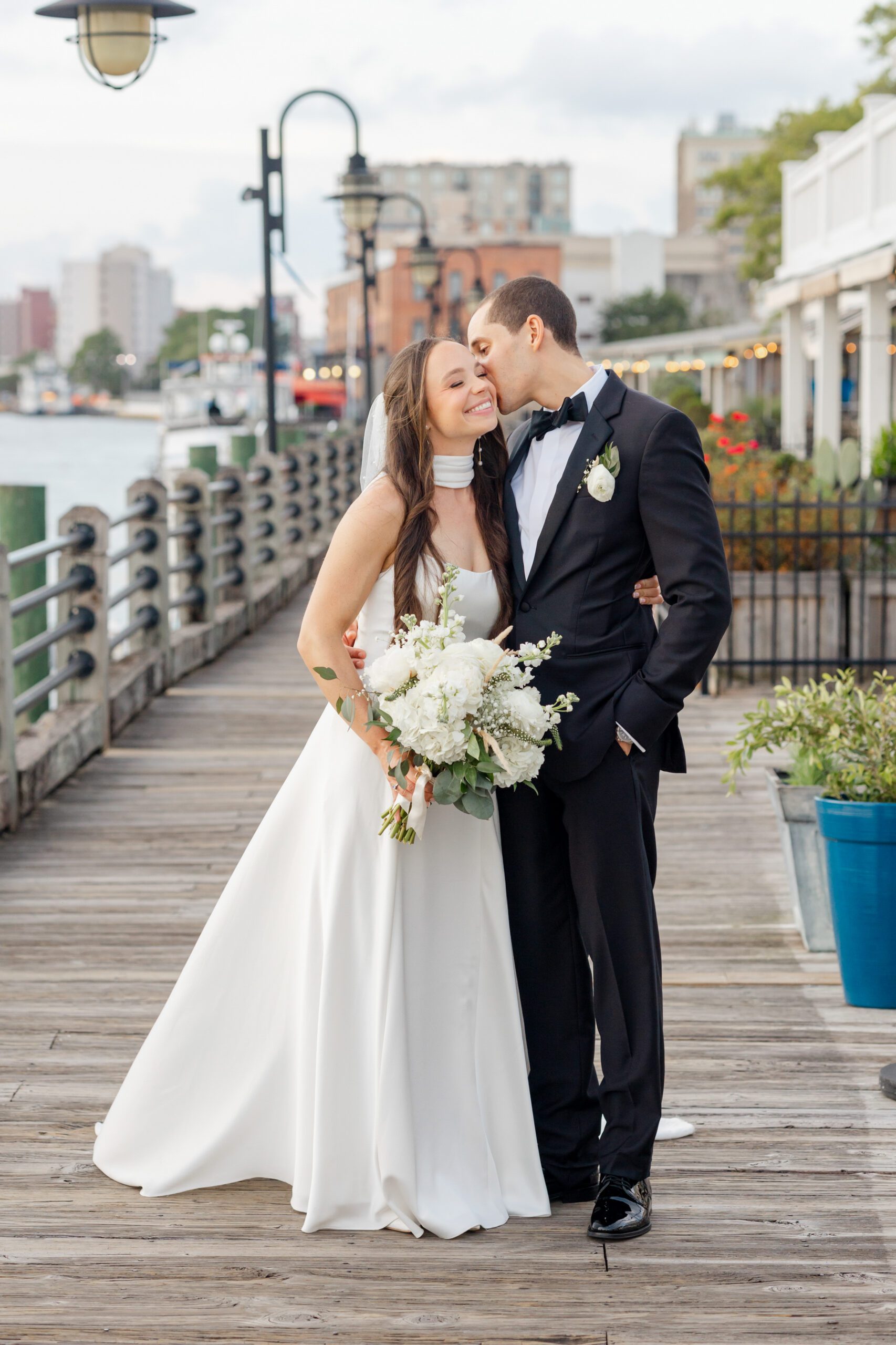 Bride and groom on the Wilmington Riverwalk, photographed by Bakery 105 wedding photographers in downtown Wilmington NC.