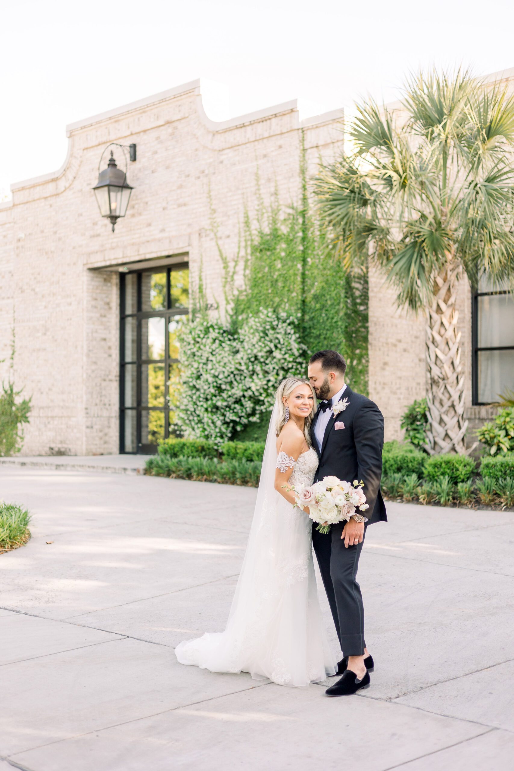 bride and groom standing together in front of Wrightsville Manor for their Wilmington NC wedding