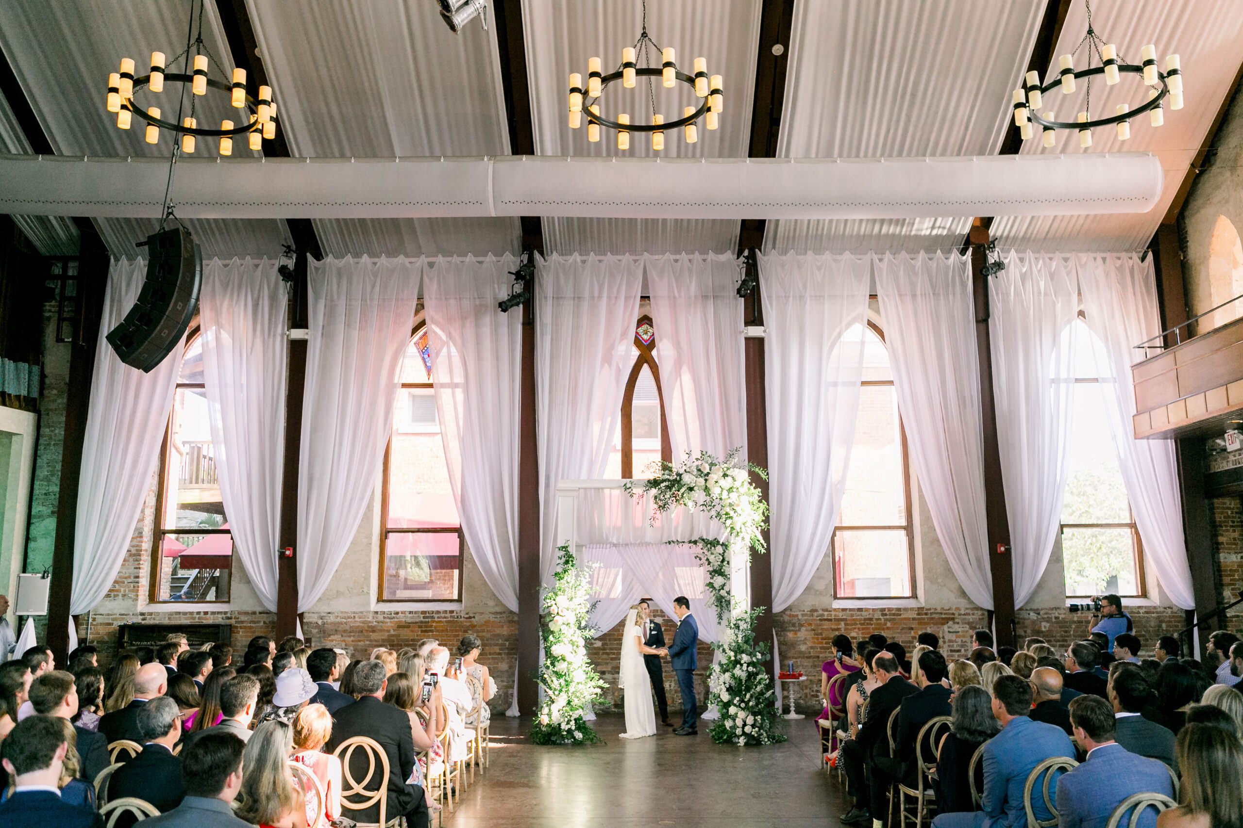 indoor wedding ceremony at Brooklyn Arts Center in Wilmington NC with guests seated in the historic sanctuary