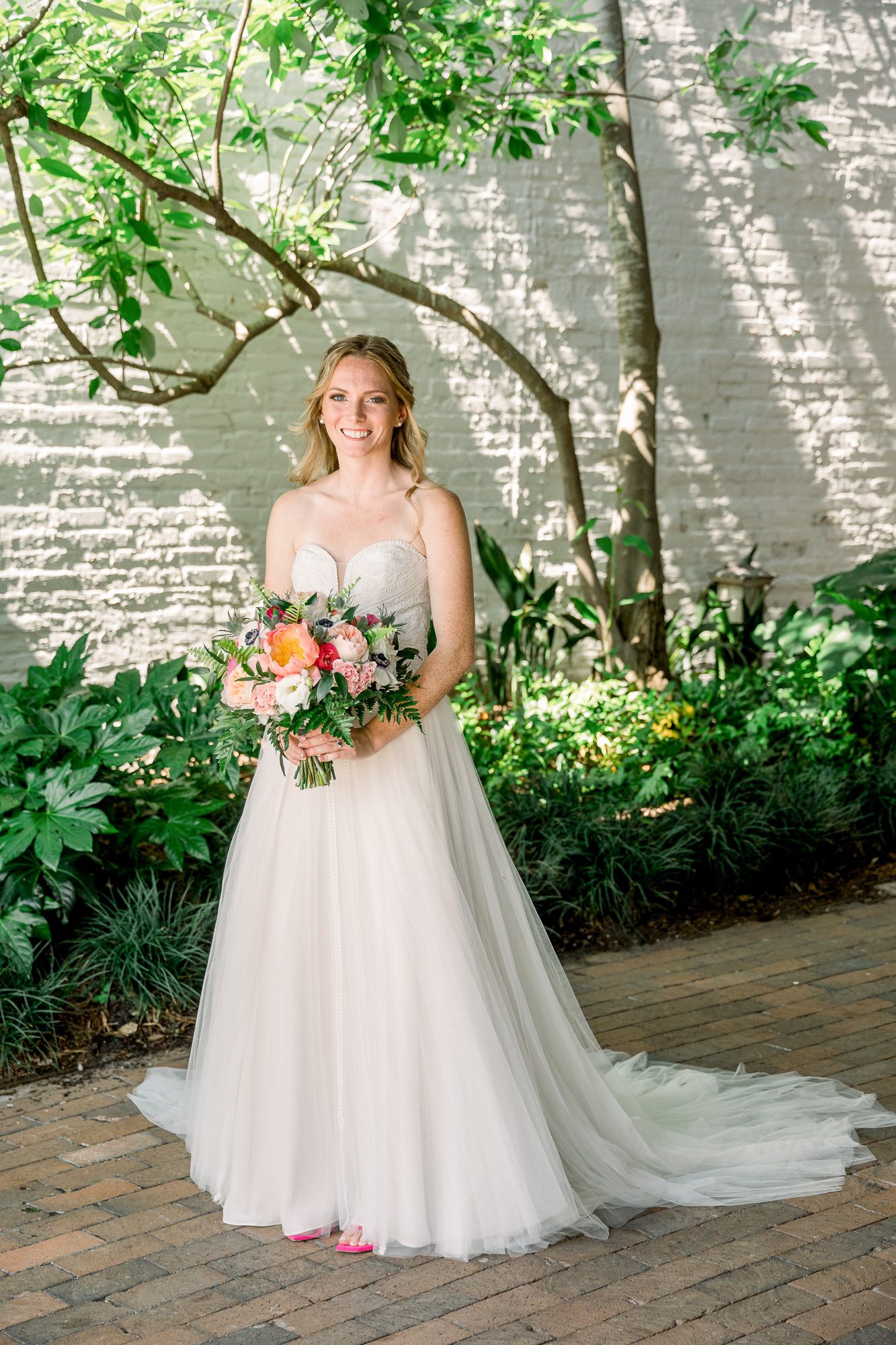 Bride standing in The Atrium courtyard with greenery captured by Atrium wedding photographers