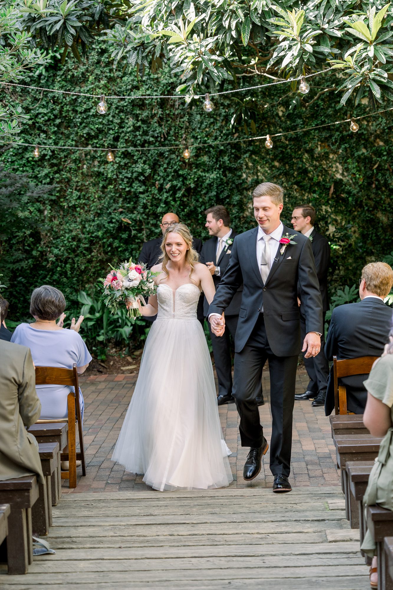 Outdoor ceremony at The Atrium in Wilmington NC with bride and groom standing in natural ligh
