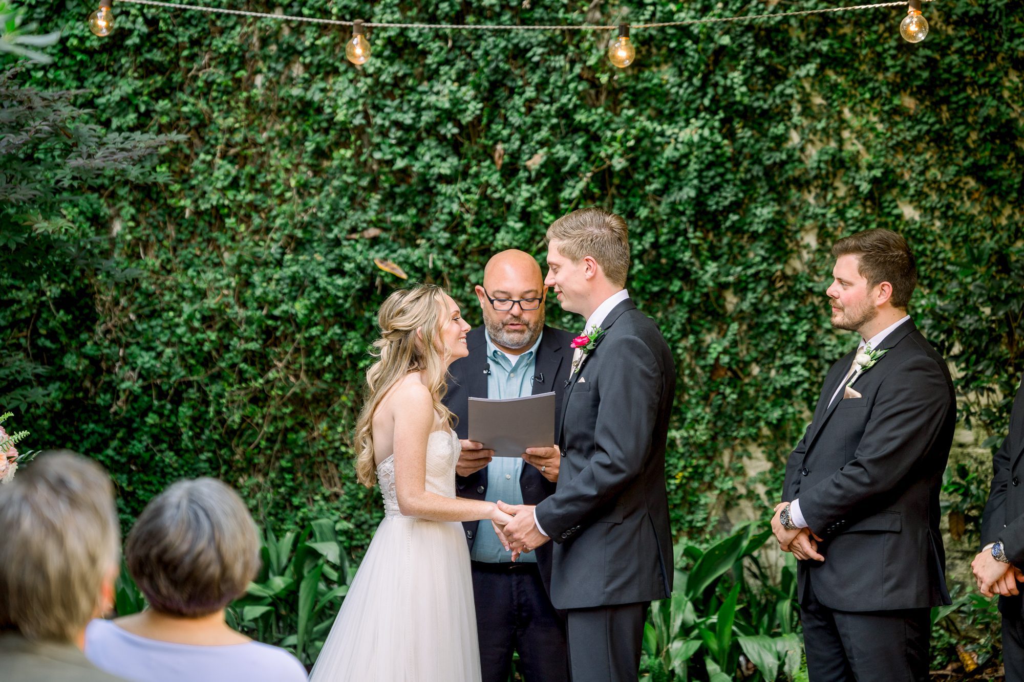 Couple exchanging vows in The Atrium courtyard captured by Atrium Wilmington wedding photographers