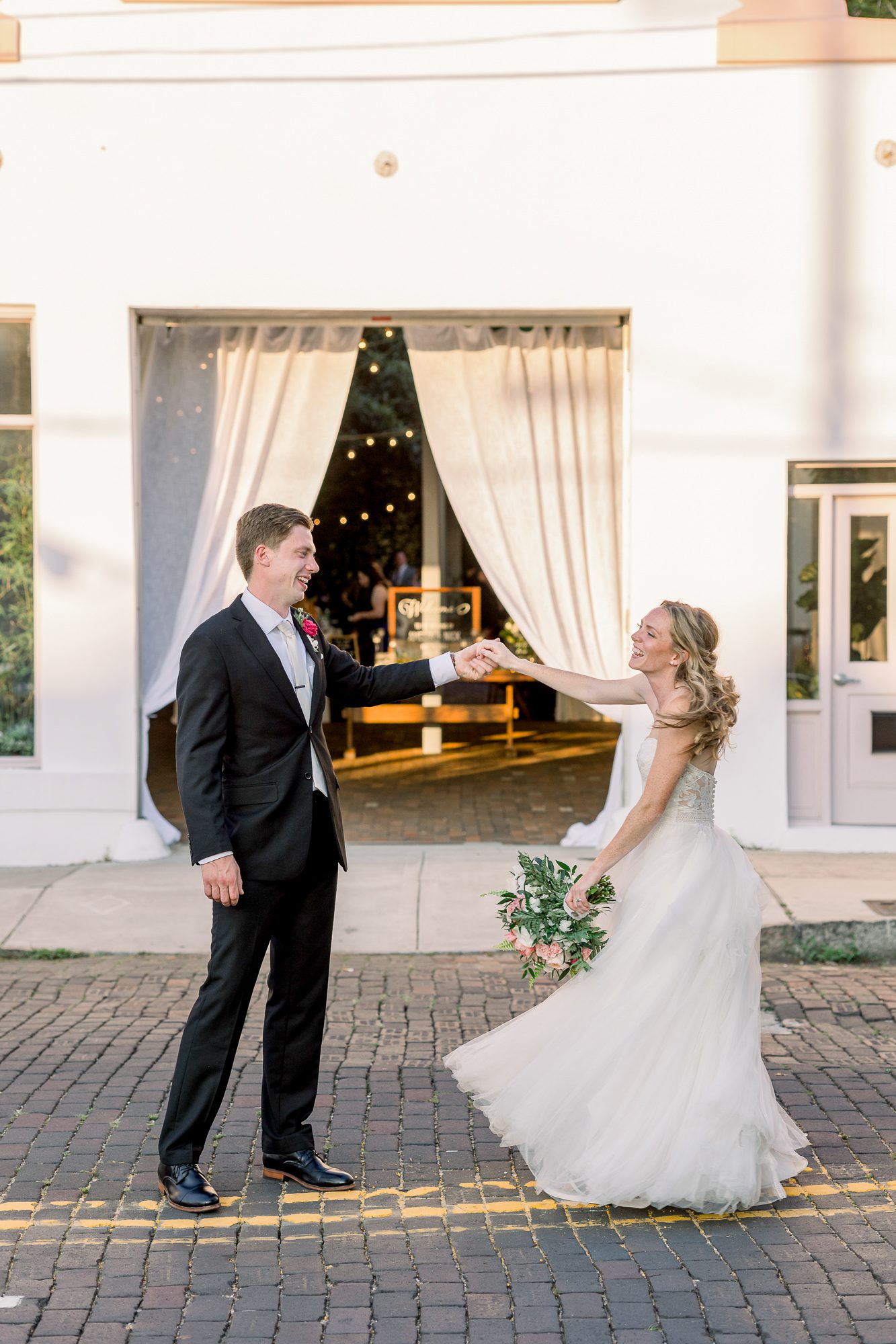 Bride and groom dancing in the street outside The Atrium Wilmington NC 