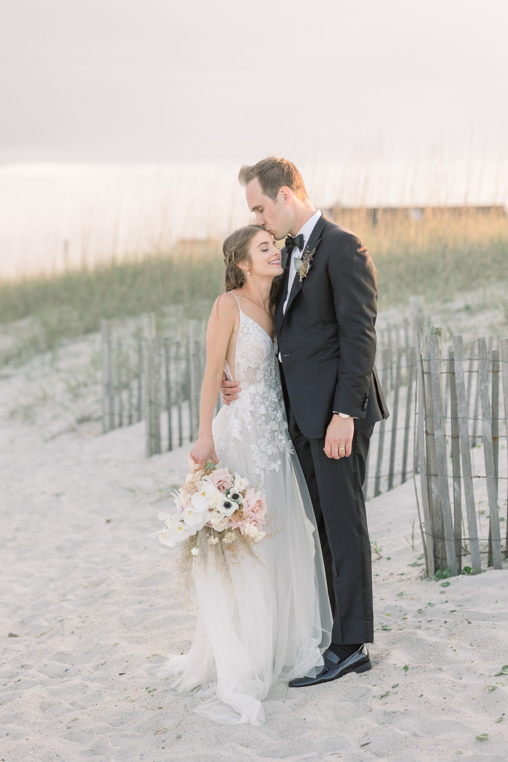 Bride and groom embracing during golden hour on Wrightsville Beach