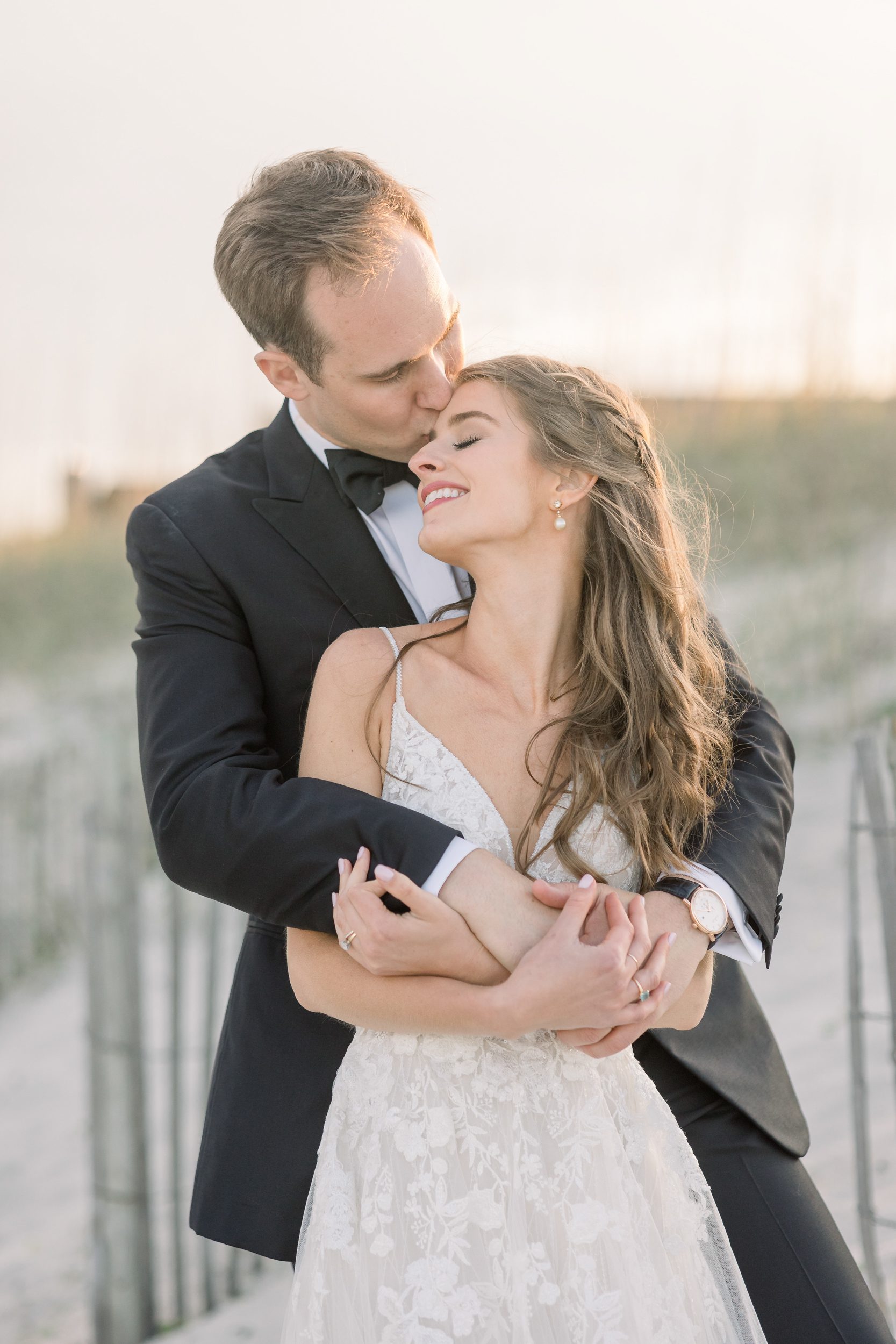 a couple embraces on Wrightsville Beach at their Carolina Yacht Club weding