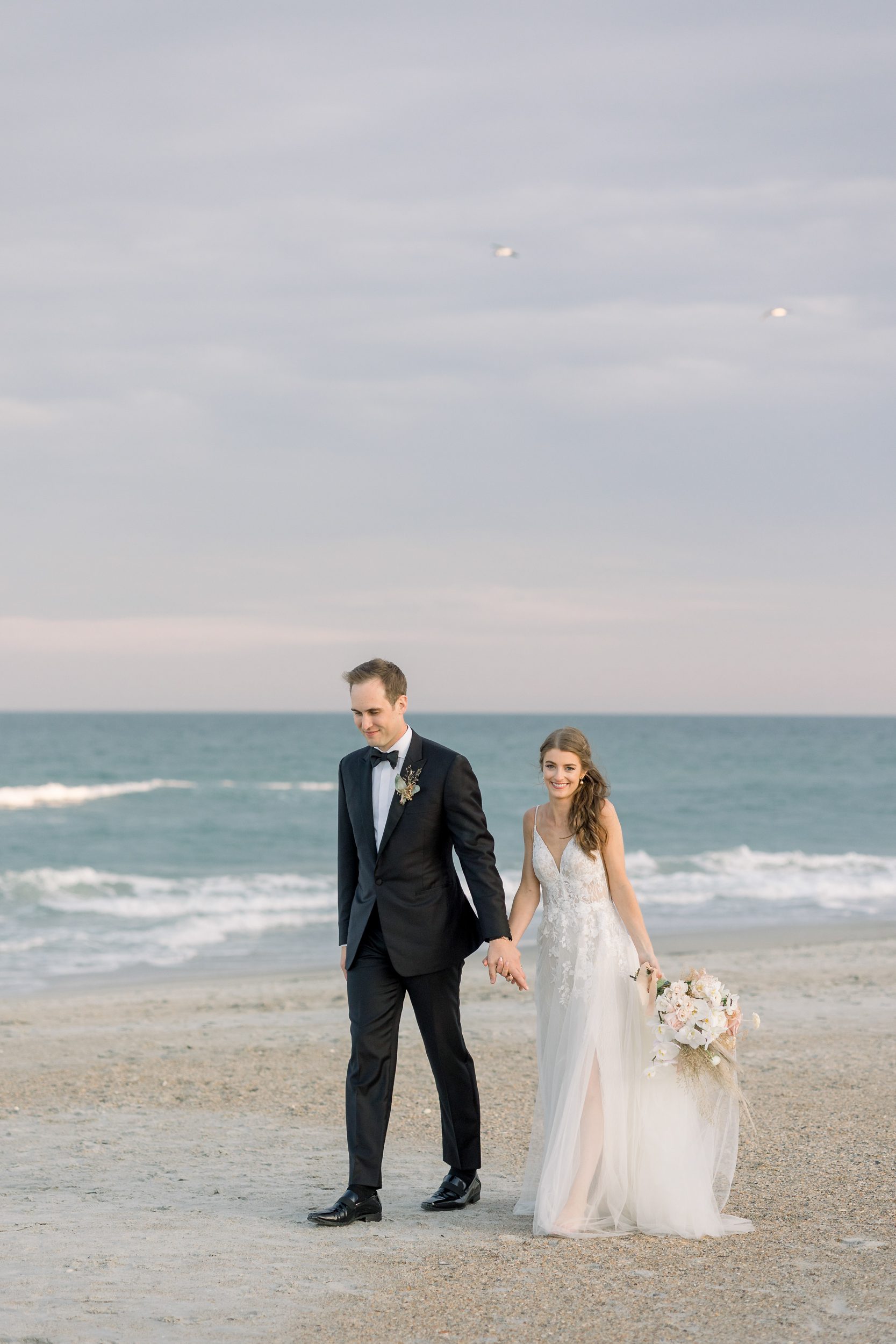 Bride and groom walking along Figure Eight for their Figure Eight Island wedding photos
