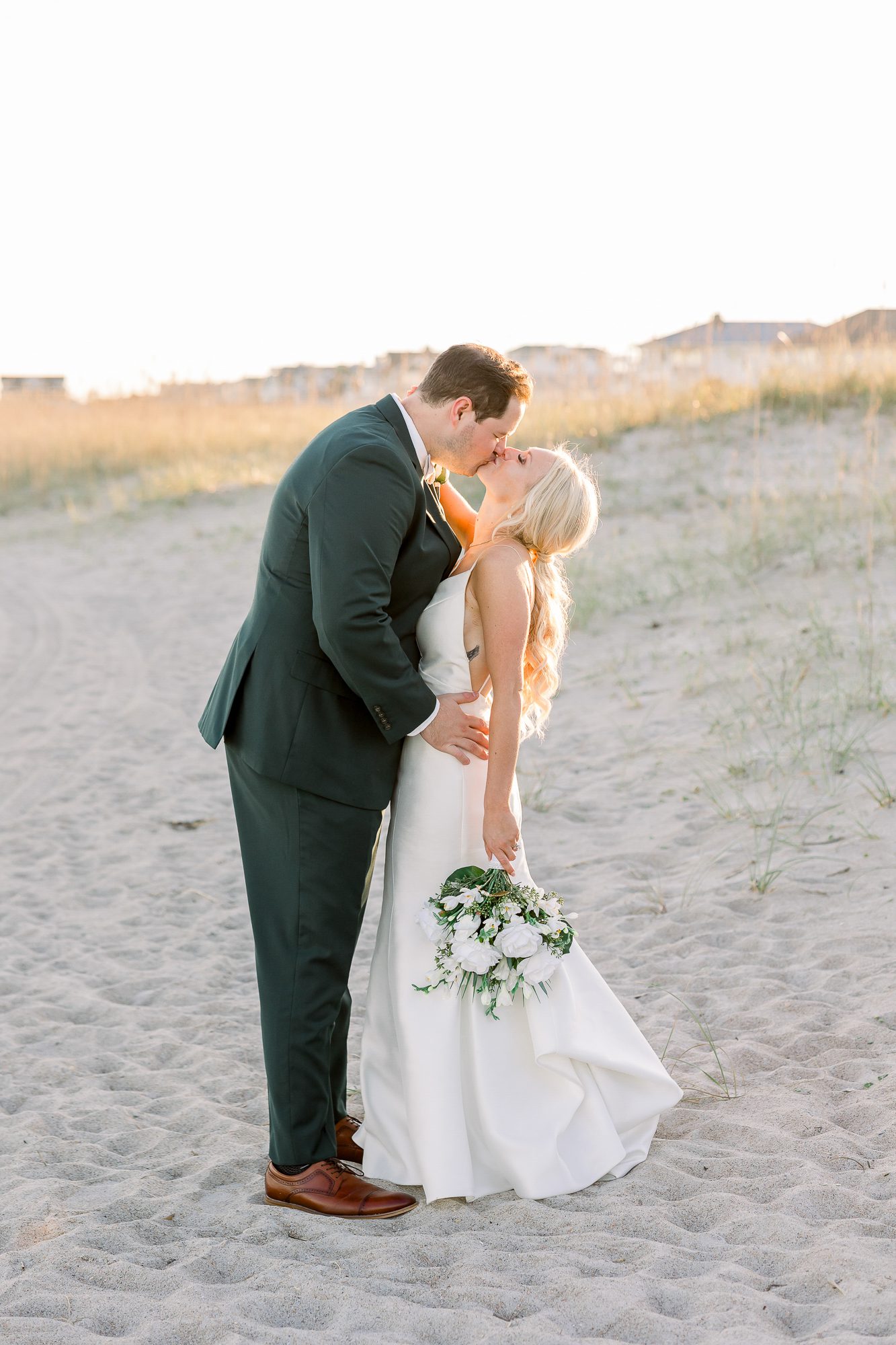 Golden hour wedding portraits of a couple on the beach near Carolina Yacht Club